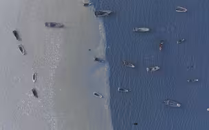 航拍长岛冻海奇观：雪浪凝固渔船定格 冰水分界宛如“鸳鸯锅”