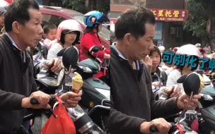 爷爷在小学门口接孩子 举着冰淇淋焦急等待 时不时瞥一眼恐怕化了
