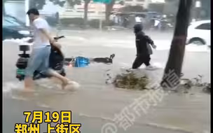 都市报道【生活不易！郑州暴雨致路面积水，外卖小哥电动车被冲走】