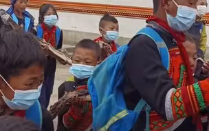 彝历年后返校第一天，学生们自发提着腊肉送给支教老师。