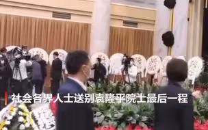 袁老遗体身覆国旗安卧鲜花翠柏丛中