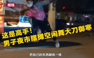 高手！男子夜市摆摊空闲舞大刀御寒