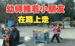 幼师推着两筐小朋友在路上走，拍摄者：又安全又有爱