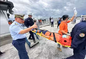 撤离中国仙宾礁潟湖的菲海警船靠岸，菲媒：4人被担架抬下船
