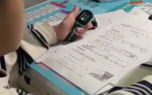 右手写作业 左手拿着电话手表 时刻准备拨打110：看你们谁敢凶我