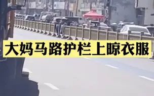 咋想的？大妈在马路中央护栏上晾衣服