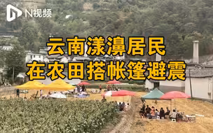云南漾濞居民在空地搭帐篷避震，救援车辆从震中方向驶出