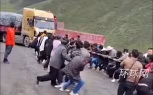 满载几十吨煤的货车陷进泥地，上百人合力拉车救援