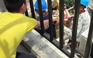 工人顶着烈日在阳台外施工，男孩主动送上西瓜解暑。解的是暑，暖的是心！