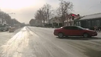 小轿车“被迫”闯红灯：路面结冰刹不住 路口失控旋转两圈半