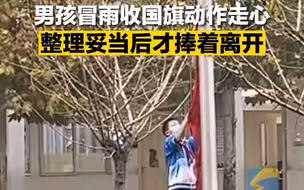 男孩冒雨收国旗每个动作都很用心