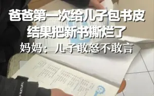 爸爸第一次给儿子包书皮 结果把新书撕烂了，妈妈：儿子敢怒不敢言