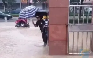 雨天为了不让孩子蹚水 山东平阴一保安单手撑伞抱其进校门