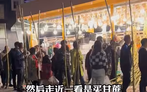 市民水果摊前买甘蔗，人手一根排队等着老板削皮，画风奇特好似“丐帮”大会