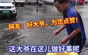 天津大雨过后街头积水，大爷手持铁钩守在下水道旁，一边清垃圾一边排水。网友：好大爷，为您点赞！