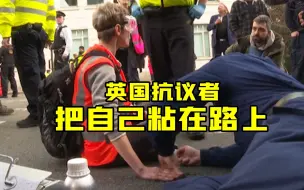 英国气候抗议者把自己粘在路上 防止被警察拖走