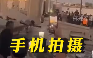 伊拉克首都巴格达交火现场：一人开火，民众围聚举手机拍摄