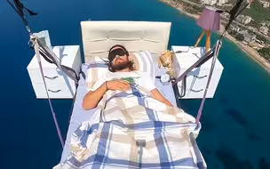 床上天了！男子边“睡觉”边飞滑翔伞 眼罩闹钟齐上阵 画面惊险刺激