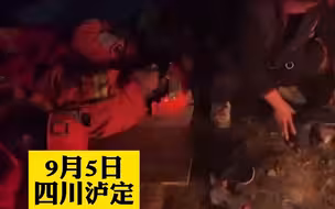 泸定地震救援现场，彻夜搜救的救援人员席地休整，老乡生起火为他们烘鞋垫和袜子