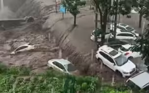 持续暴雨导致山洪暴发 男子眼睁睁看着自家车被冲走成“废铁”