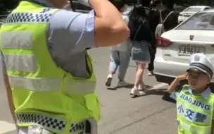 上阵父子兵！萌娃穿交警服陪父亲护航中考。小交警也通过自己的方式给此次中考的哥哥姐姐送去祝福