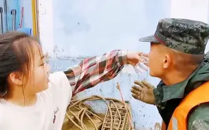 小朋友踮脚喂满手泥的兵哥哥喝水