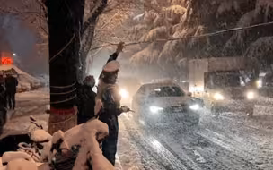 山西晋城下起了大雪，因降雪路面电线下垂，执勤交警当上了最美“支架”。