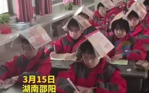湖南一老师为了纠正孩子们的坐姿，想出妙招：让学生顶着课本写作业