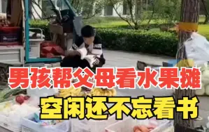 男孩早起帮父母照看水果摊，空闲时间还不忘看书