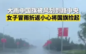 大雨中国旗被风刮到路中央 女子冒雨折返小心将国旗捡起
