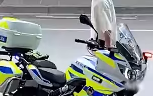 6月13日，江苏南京。交警在开罚单，一名摩托车迷被铁骑吸引，转圈围观过瘾