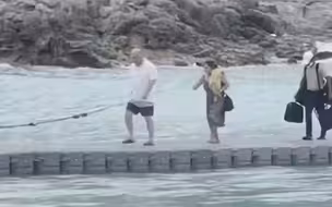 游客们准备从浮桥回到海岸，没想到被海浪打翻，网友：这是现实版西游记吧。