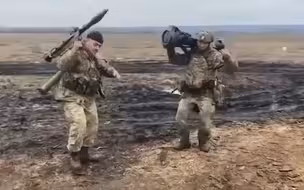 乌克兰士兵肩扛着RPG火箭筒嗨跳战舞 身后是刚激战过的一片焦土