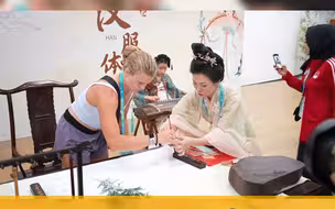 笔走龙蛇，行云流水，参加大运会的外国运动员体验中国书法