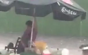 大雨滂沱 周边商贩陆续离开 卖菜老人独自撑伞坚守 手足无措的样子令人心疼！